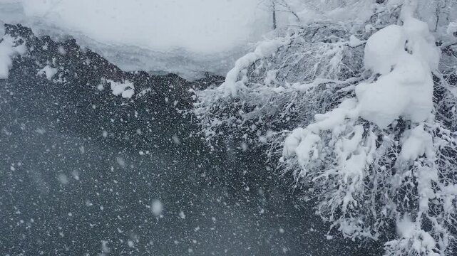スーパースロー映像：ドローンで空撮した、大雪の日の川の上の風景