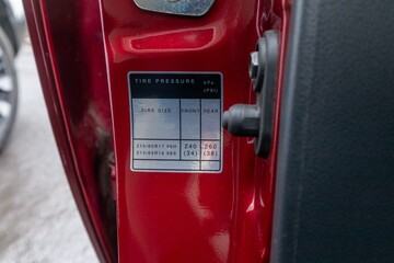 Car tire pressure sticker attached to the red car