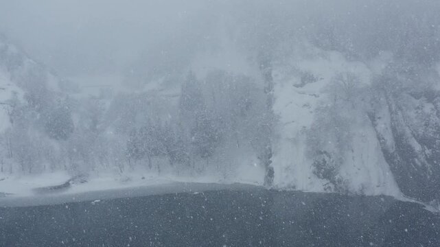 スーパースロー映像：ドローンで空撮した、大雪の日の川の上の風景