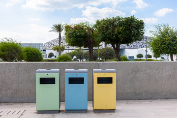 Blue, yellow and green recycling bins for separate garbage on street in Abu Dhabi, Emirates. High quality photo