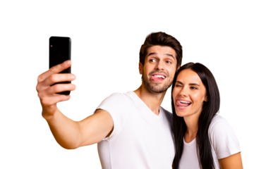 Photo of two people holding telephone taking selfies sticking tongues out of mouth playful mood wear casual clothes isolated yellow color background