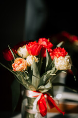 Bright tulips in a vase reflecting sunlight near a mirror, enhancing spring's beauty in an elegant setting