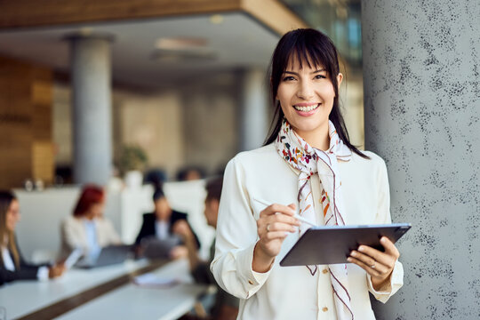 Confident Businesswoman Holding a Tablet in a Modern Office Environment