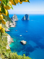 Capri, Italy, with iconic Faraglioni rocks and turquoise waters of Mediterranean sea. Bright yellow...