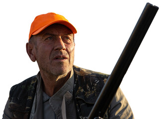 Mature man hunter with gun while walking on field.