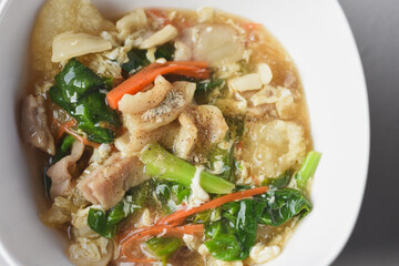 Stir-fried noodles with pork and kale, served with pork on top. Chinese-Thai food, called 
