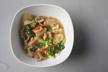 Stir-fried noodles with pork and kale, served with pork on top. Chinese-Thai food, called 