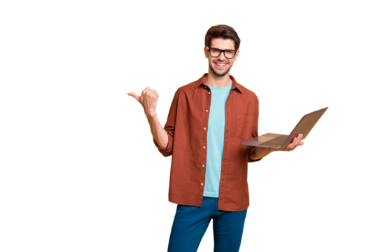 Portrait of his he nice attractive cheerful successful content brunet guy holding in hands laptop pointing thumb aside ad advert solution isolated over beige color pastel background