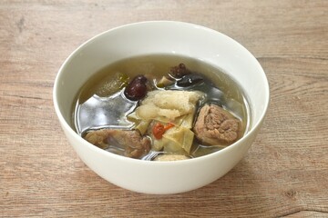 boiled bamboo mushroom with pork bone and black ear mushroom in clear Chinese herb soup on bowl