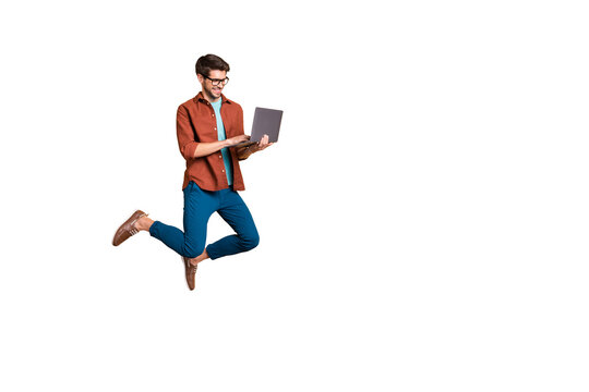 Full length body size view of his he nice attractive cheerful cheery successful brunet guy jumping in air using laptop home-based job isolated over beige color pastel background