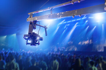 Filming concert with camera. Filming equipment suspended above audience. Camera crane in nightclub. Videographer camera with stabilizer. Filming concert with professional equipment. Creative focus