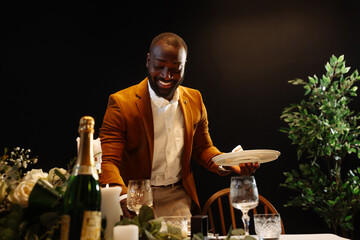 Waiter preparing table for romantic dinner in elegant restaurant
