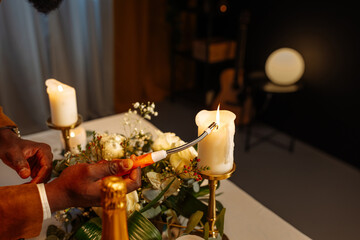 Waiter lighting candles on table for romantic dinner