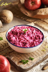 A bowl of vegetable salad made of fresh beetroot, apples and sour cream