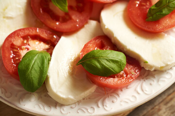Closeup of fresh tomatoes, mozzarella cheese and basil in an Italian Caprese salad