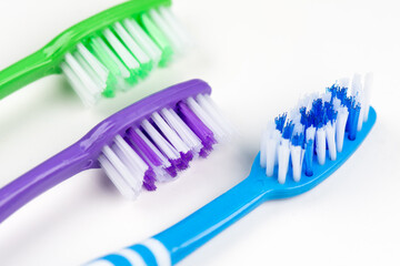 Three toothbrushes on a white background close-up. Tools for dental and oral care.