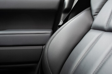 Car black leather interior. Part of black leather car seat details with white stitching. Interior...