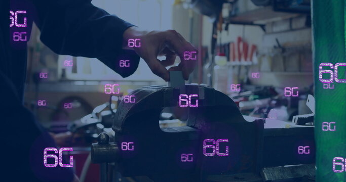 Image of 6g text in pink over caucasian craftsman using vice at workshop - Powered by Adobe