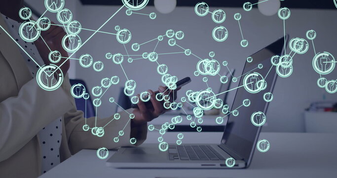 Image of network of connections with icons over american businesswoman using smartphone