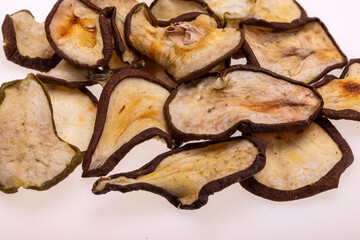 Closeup of a pile of dried slices of pears isolated on a white background. Healthy raw vegetarian eat from thin fruit chips of sweet and sour flavor