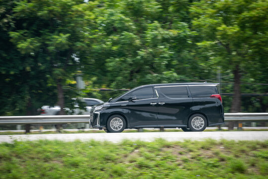 Nakhonsawan, Thailand - July 2024: A black Toyota Alphard runs at speed on a highway on July 27, 2024, in Nakhon Sawan, Thailand.