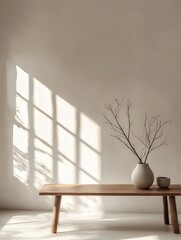 a minimalist studio with a simple wooden table, a ceramic vase holding a few dried branches