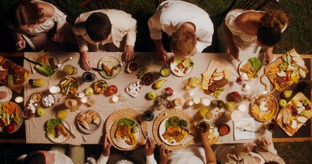 Top view of a beautifully laid festive table. Guests eat and talk while sitting at the table outdoor