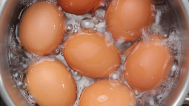 Chicken eggs boiling in hot water. Top view