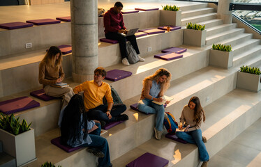 University students studying and working on laptops in modern open space area
