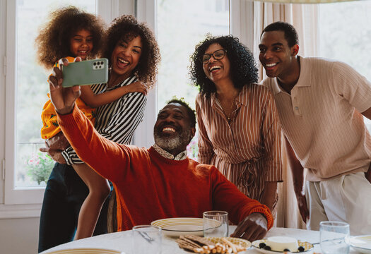 Storytelling image of a Family reunited at parents house  for lunch on the holidays. Family members celebrating at home eating good food, sharing love and positive emotions.