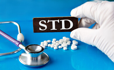 Cubes with the abbreviation STD in the hand of a doctor.