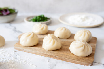 Close-up of raw gyozas covered in flour, a homemade dumpling-making process.