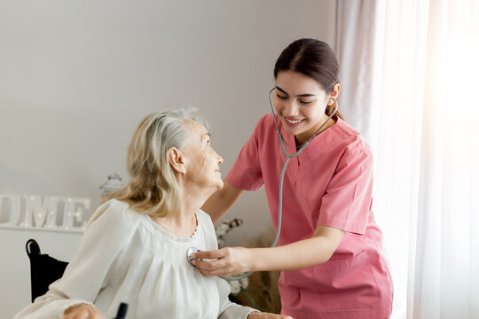 Caucasian caregiver lady consulting with elderly woman patient. Wheelchair disability rehabilitation and nurse at nursing home. Healthcare support and caregiver with senior woman for medical help.