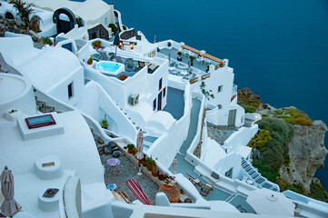 Touristic spot and tourism. Traveling. Santorini island architecture landscape in evening. Top view on architecture. Night touristic city with sea and volcanic mountain. Travel destination