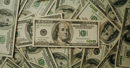 Hundred dollar bills are scattered on the table. Overview of the details of paper money