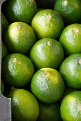 Green lime. Selective focus. Fresh ripe juicy limes as a food background or texture. Green lemon fruits in a box.     