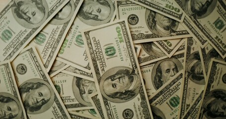 Hundred dollar bills are scattered on the table. Overview of the details of paper money