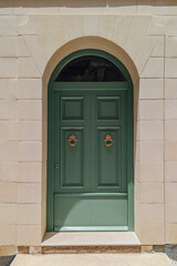 Elegant entrance crowned by subtle arch emphasizes local heritage, entrance capturing graceful lines of woodwork, entrance uniting old charm and modern city living in Maltese context
