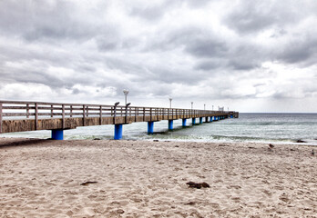 Fototapeta premium A beach with a pier on Baltic Sea in Germany. The water is blue