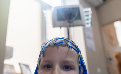 A boy's brain is examined on an EEG machine. Electroencephalogram is performed in a hospital...