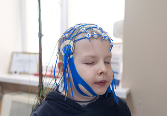 A boy's brain is examined on an EEG machine. Electroencephalogram is performed in a hospital...
