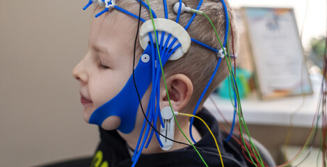A boy's brain is examined on an EEG machine. Electroencephalogram is performed in a hospital...