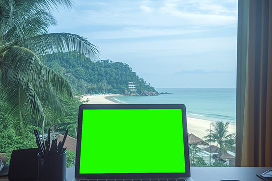 Tropical Workspace: A laptop with a vibrant green screen sits by a large window, offering a stunning panoramic view of a tropical beach and ocean, suggesting remote work or digital nomad lifestyle.  - Powered by Adobe