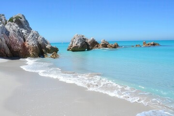 A serene beach scene featuring clear turquoise waters, gentle waves lapping at the shore, and rocky formations under a bright blue sky.