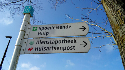 Sign posts with direction to the first aid, pharmacy and the general practice center near a Dutch hospital in the Netherlands