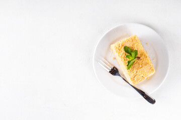 Homemade Napoleon cake slices, layered mille-feuille cake with vanilla creamy custard, tasty delicious puff pastry, on serving plates with forks, copy space