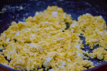 close up of scrambled eggs with cheese in a pan