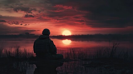 Fototapeta premium Silhouetted soldier rests, sunset lake.
