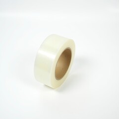 a small, transparent roll of clear magic tape, its beige cardboard core visible through the transparent plastic, is precisely centered on a pristine, snow-white background