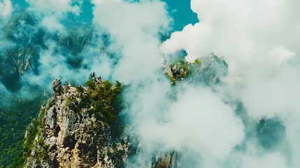Scenic Aerial View of Rugged Mountain Peaks Emerging from Dense White Clouds Under Blue Sky